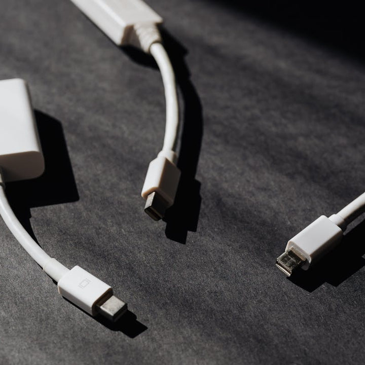 Cabos e adaptadores HDMI brancos em superficie escura